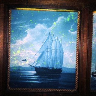 A vintage sailing ship on stormy seas at dusk.