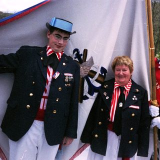Uniformed guards and honored civilian in ceremonial attire.