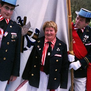 Uniformed guards and honored civilian in ceremonial attire.