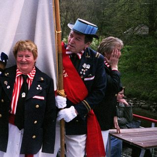 Uniformed guards and honored civilian in ceremonial attire.