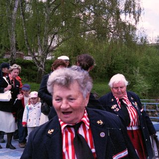 People in traditional clothing at outdoor event.