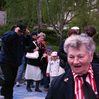 People in traditional clothing at outdoor event.