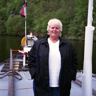Woman standing on a boat near water.