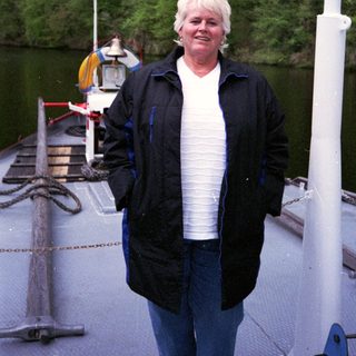 Woman standing on a boat near water.