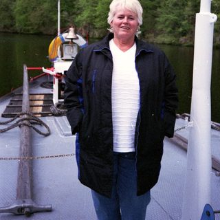 Woman standing on a boat near water.