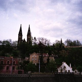 Historic town with twin-towered church and hillside buildings.