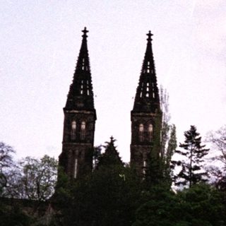 Historic town with twin-towered church and hillside buildings.