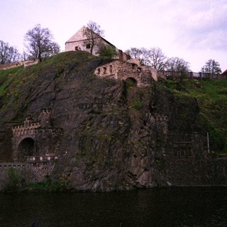Historic castle ruins on rocky hillside.
