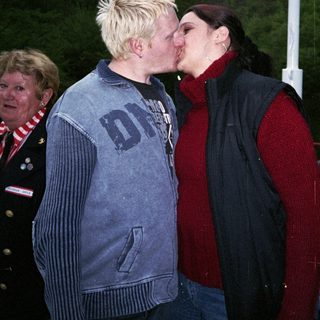 Two people sharing a kiss outdoors.