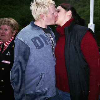 Two people sharing a kiss outdoors.