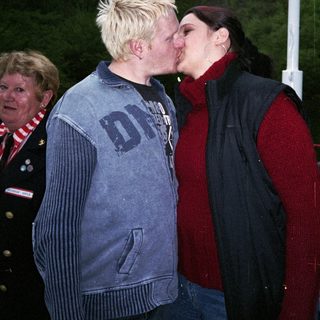 Two people sharing a kiss outdoors.