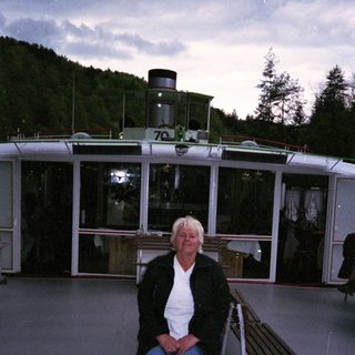 Person sitting on boat deck at dusk.