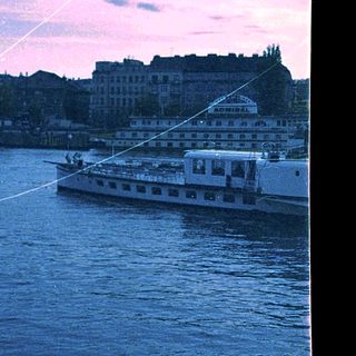 Boat on river during twilight near city.