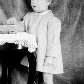 Young girl playing with toy train set.