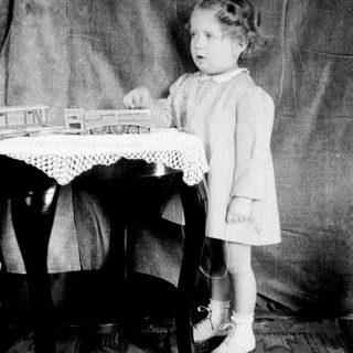 Young girl playing with toy train set.