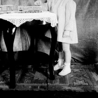 Young girl playing with toy train set.