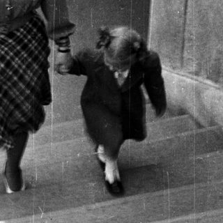 A woman and child walking down stairs together.