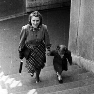 A woman and child walking down stairs together.