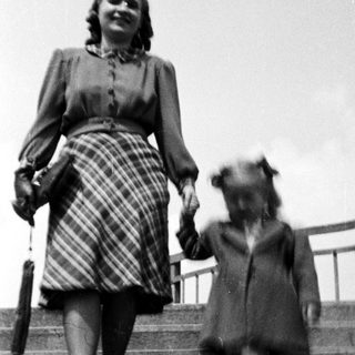 A woman and child walking down stairs together.