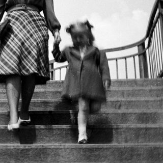 A woman and child walking down stairs together.
