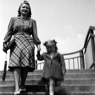 A woman and child walking down stairs together.