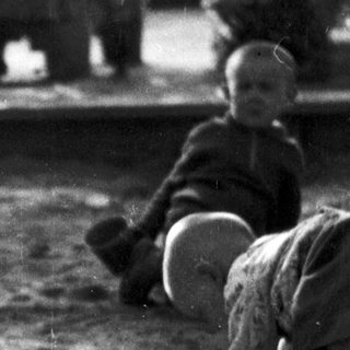 Young children playing in outdoor sand area.