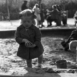 Young children playing in outdoor sand area.