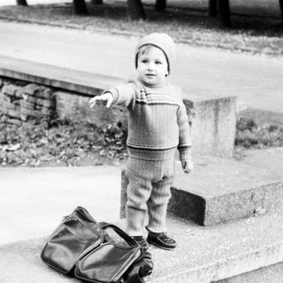 Young child pointing while standing on steps.