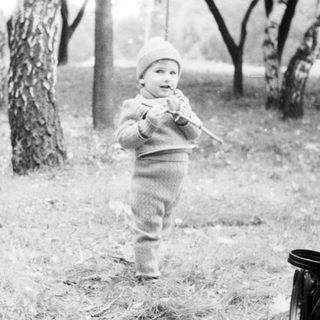 Toddler playing outdoors in park with toy.