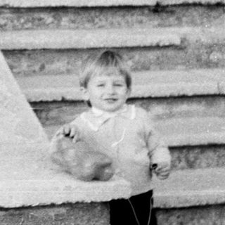 A man and young child standing outside on steps.