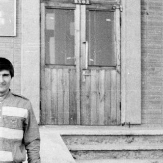 A man and young child standing outside on steps.