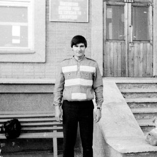 A man and young child standing outside on steps.