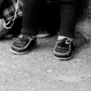 A woman holding a young child outdoors.
