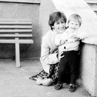 A woman holding a young child outdoors.