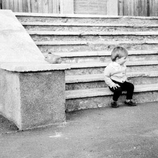 Toddler sitting alone on stone steps.