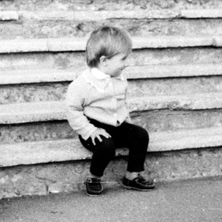 Toddler sitting alone on stone steps.