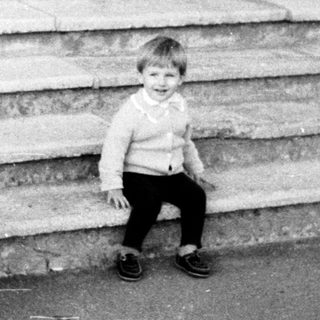 A child sitting alone on concrete steps.