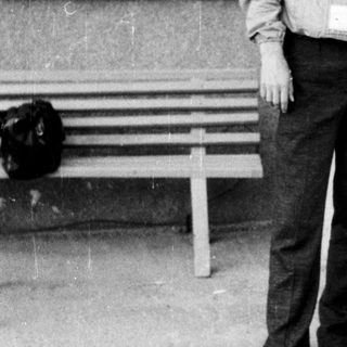 Young man standing on stairs in casual 1970s-style clothing.