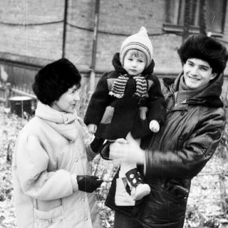 Family posing outdoors in winter with camera.