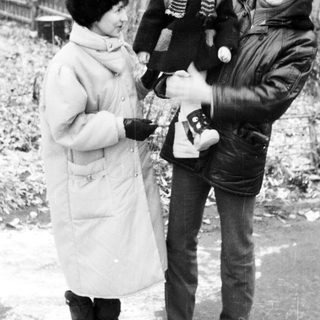 Family posing outdoors in winter with camera.