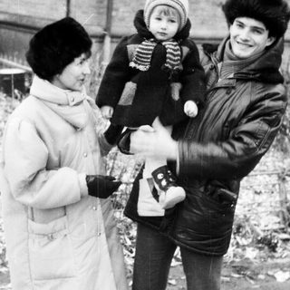 Family posing outdoors in winter with camera.