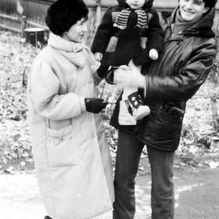 Family posing outdoors in winter with camera.