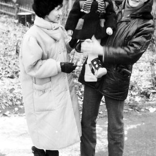 Family posing outdoors in winter with camera.