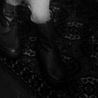 Young child standing indoors near bucket.