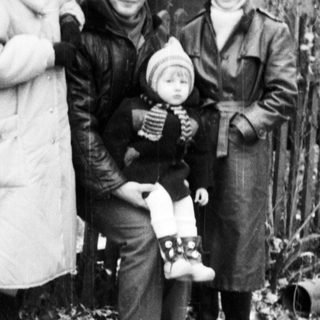 Three women and a baby outdoors in winter attire.