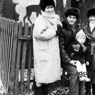 Three women and a baby outdoors in winter attire.