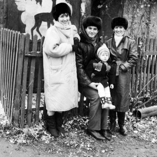 Three women and a baby outdoors in winter attire.