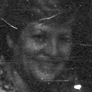 Vintage black-and-white photo of woman sitting indoors.
