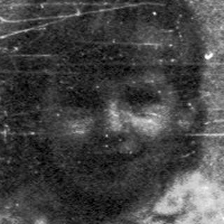 Silhouette of person sitting on dark, worn steps.