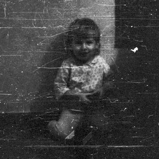 Silhouette of person sitting on dark, worn steps.